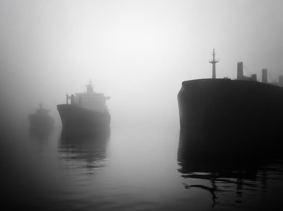 Cargo ships in a foggy harbour representing international trade